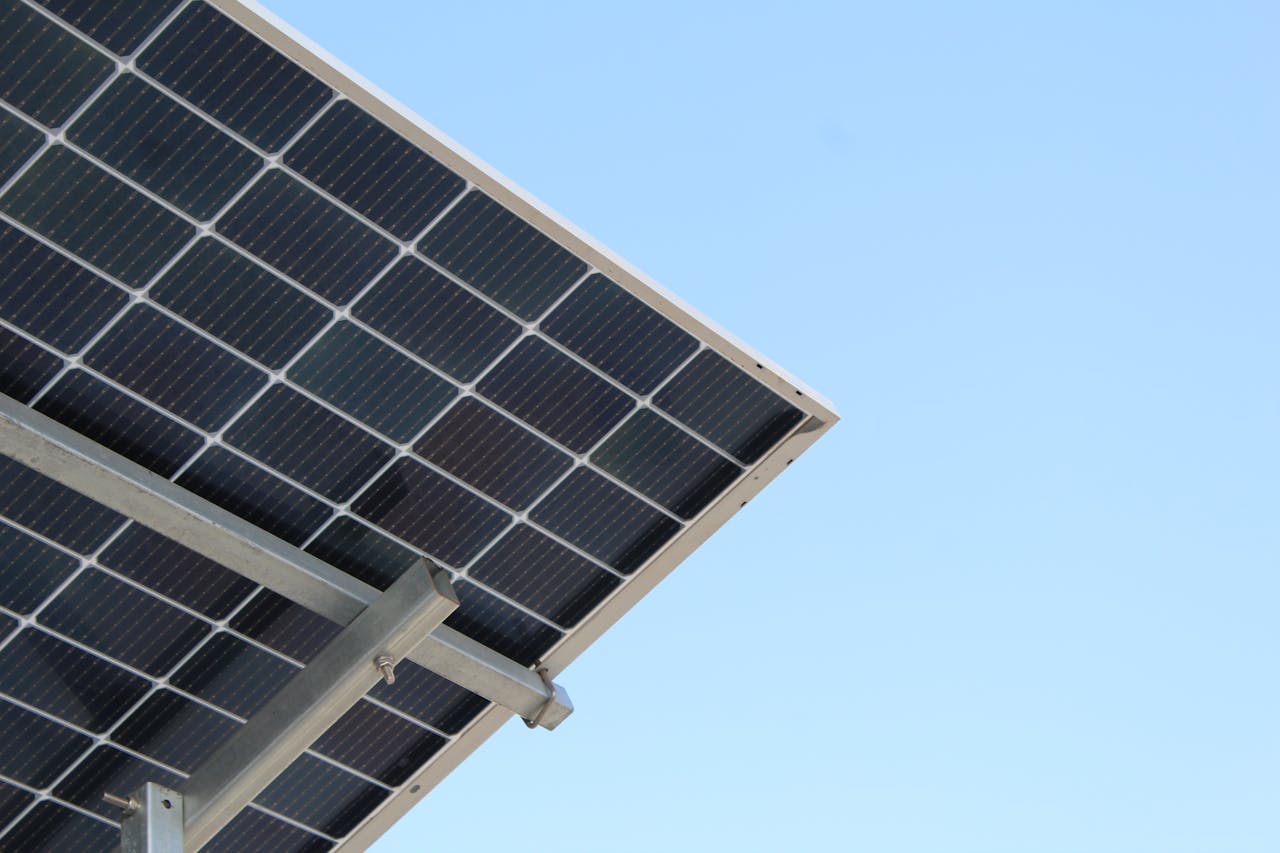 A modern solar panel with a clear blue sky background, highlighting renewable energy.